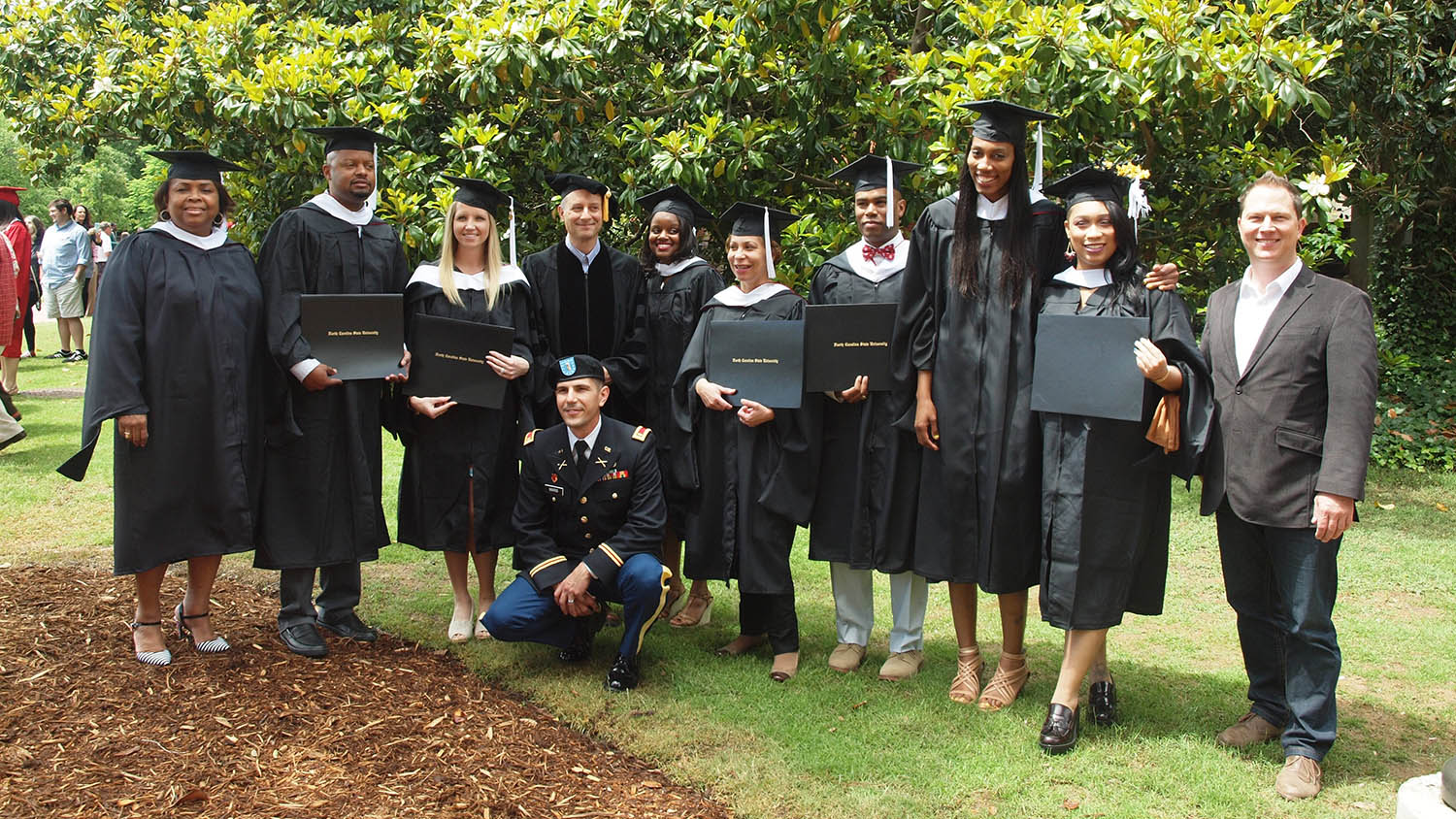 group of graduates stand with Seth Murray